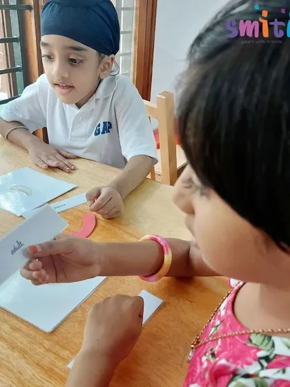 Two students discuss the parts of a bee using nomenclature cards. This language activity expands their scientific vocabulary.