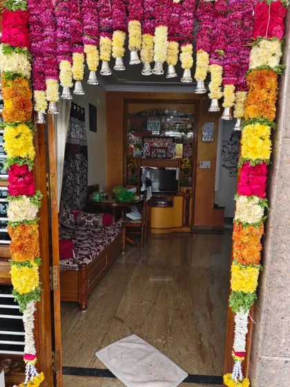 A colorful flower garland framing the entrance to a home. This is a classic decoration for housewarmings, festivals, and other family gatherings.