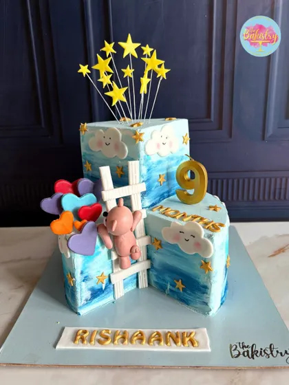 This adorable cake celebrates Rishaank's 9-month milestone. The design features a teddy bear climbing a ladder to the stars, symbolizing the exciting journey to his first birthday.