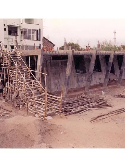 This construction site image documents the raw structure, highlighting the angular form designed to withstand coastal conditions while minimizing the use of metal.