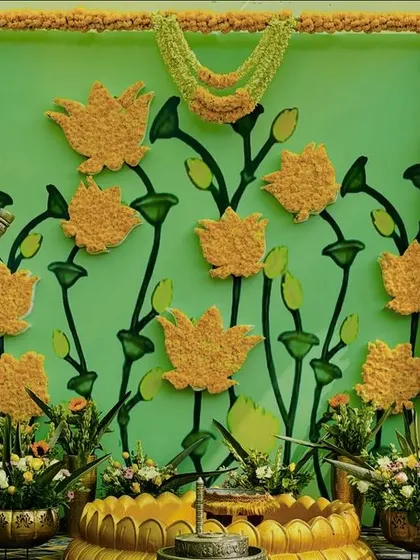 The full view of our pichwai-inspired Haldi backdrop, with its intricate floral details, traditional pillars, and brass vessels.