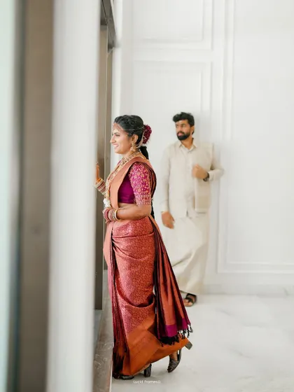 A beautifully composed shot of the couple in a modern, bright interior, the bride looking out the window.