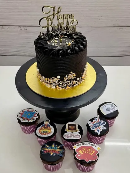 A hero's treat. This combo of a rich black birthday cake and "Super Dad" themed cupcakes is perfect for the man who plays every role in your life.