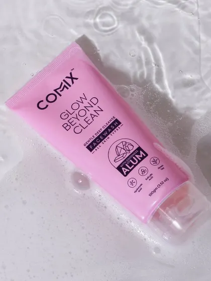 A refreshing shot of a face wash tube floating in rippling water. The pink color of the product stands out against the water, creating a clean and hydrating visual.