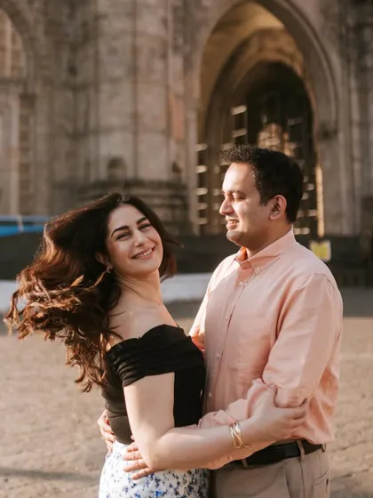 A dynamic shot with her hair in motion, adding a sense of life and energy to this romantic portrait in front of a historic Mumbai building.