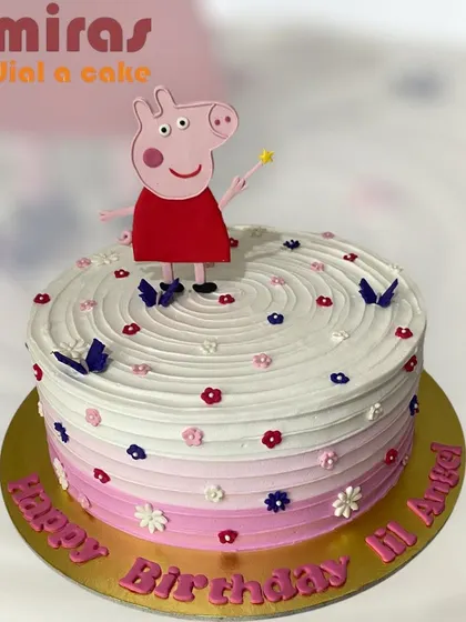 A fun and colorful Peppa Pig cake with a raspberry flavor. Peppa stands on a swirl of pink and white frosting, surrounded by tiny flowers and butterflies, perfect for a little angel's birthday.
