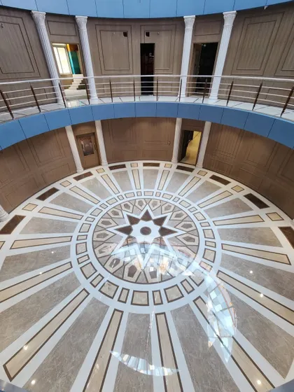 A top-down view of the completed marble floor pattern inside the Arihant Aspire clubhouse rotunda.