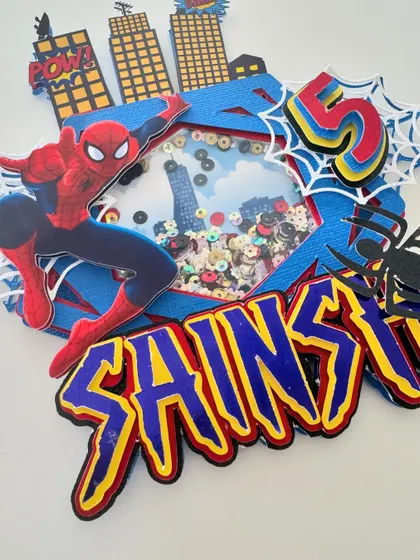 Our Spiderman shaker topper is full of action. It features Spidey swinging over a city skyline, with a shaker window filled with themed confetti.