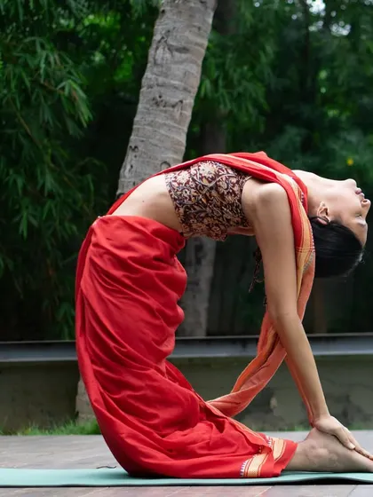 This is the Ustrasana, or Camel Pose, a deep backbend that opens up the chest and improves spinal flexibility. I love how practicing yoga in a saree connects me to my roots while I flow.