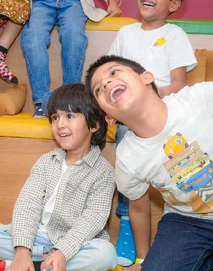 Two boys share a laugh while watching the party entertainment.