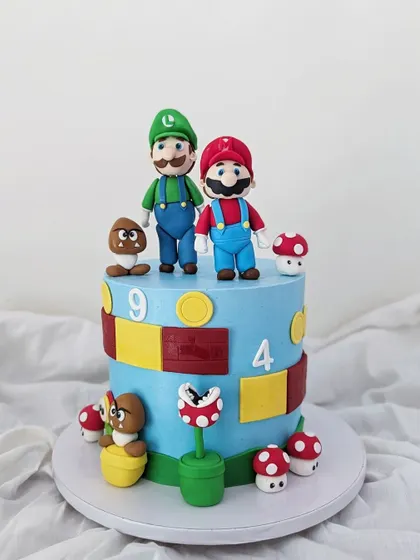 A full view of the Super Mario cake, complete with coins, blocks, and a piranha plant.