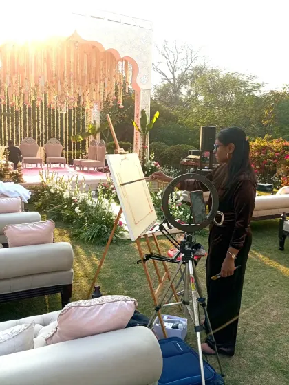 Painting in the golden hour light at an outdoor wedding at ITC Maurya. The natural light was perfect for capturing the soft colors of the decor.