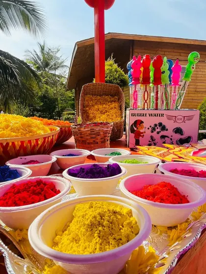A table set up with colorful powders and flower petals for a fun and messy Haldi celebration.