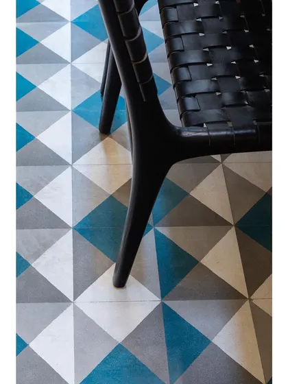A flooring detail from Nataraj House, where geometric cement tiles in shades of blue and grey create a rug-like effect.