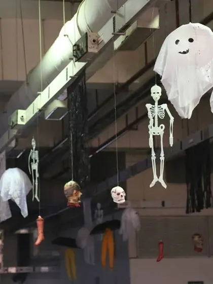 We use hanging props to fill the space and add to the haunted feel. This setup includes skeletons, ghosts, and other spooky items suspended from the ceiling.