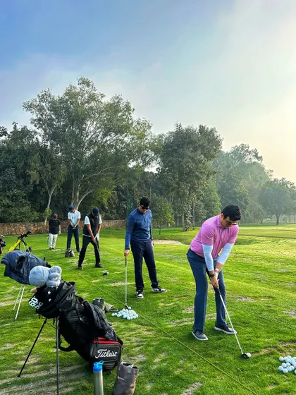 From first light to last shot, the grind never ends. A golfer practices on the chipping green.