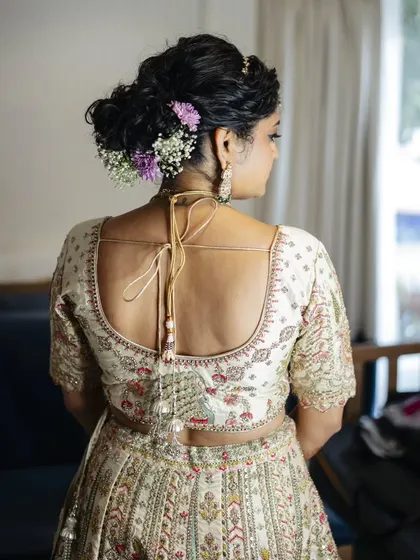 A close-up of a messy, textured bun for a sunset wedding. I incorporated delicate baby's breath and other small flowers for a soft, romantic touch.