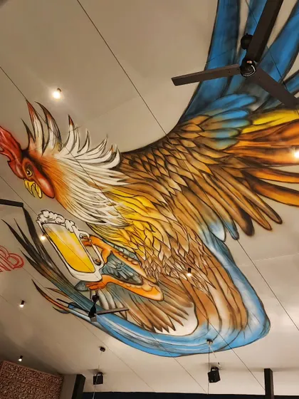 Why limit art to walls? For Plan B in Kammanahalli, we painted this huge, dynamic rooster mural directly onto the ceiling, creating an immersive and unexpected art experience for diners.