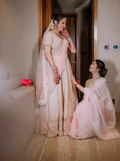 A sweet, candid moment between the bride and her sister or friend during the getting-ready process.