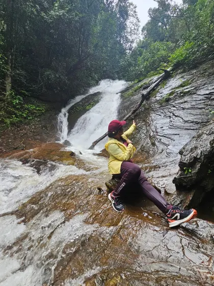 A trekker enjoying the refreshing cascade of Hidlumane Falls, a key attraction on the Kodachadri trek.
