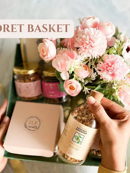The Floret Basket is one of our most charming options. It's a metal tray-style basket that we fill with treats and a lovely floral arrangement.