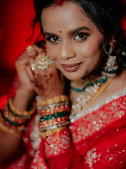 A close-up shot focusing on the bride's intricate jewelry and henna.