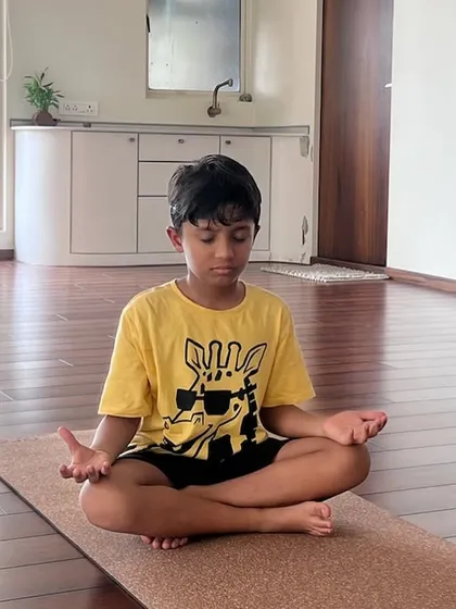A young yogi finds his center in a seated meditation pose. It's never too early to learn the power of a quiet mind.