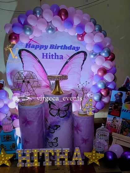 A beautiful butterfly-themed 4th birthday party with a round backdrop and a purple and silver color scheme.