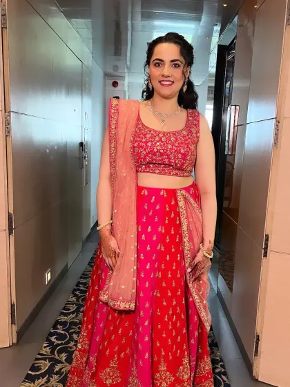 This client is ready for her pre-wedding function in a bright pink lehenga. Her makeup is fresh and vibrant, matching the celebratory mood.