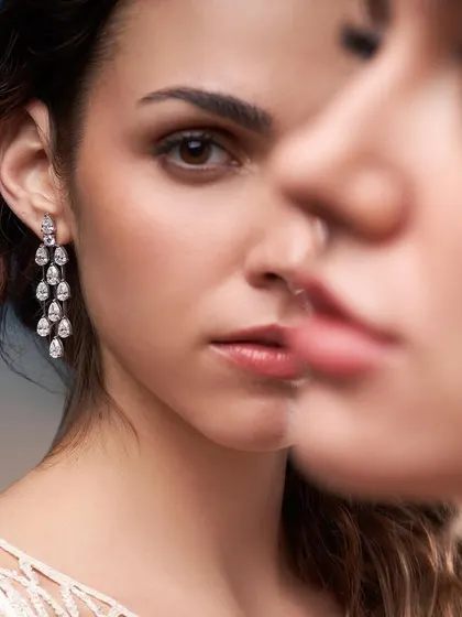 A creative portrait for Solitario Diamonds, using a reflection to create a sense of duality. The focus remains on the stunning diamond drop earrings.
