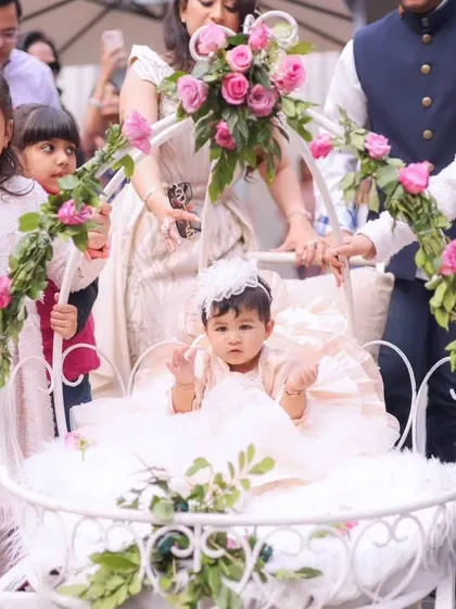 A heartwarming moment as the birthday girl makes her entrance in a beautiful white carriage adorned with fresh pink roses.