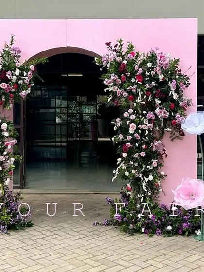 The grand entrance we designed for Arha's tonsure ceremony. A large pink archway adorned with fresh flowers and a personalized welcome sign created a memorable first impression for guests.