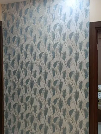 A hallway wall covered in a delicate feather pattern wallpaper. The design adds a soft and graceful touch to the transitional space.
