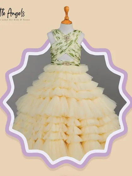 The Poppy Cream Gown features a printed, structured top and a voluminous cream colored ruffled skirt.