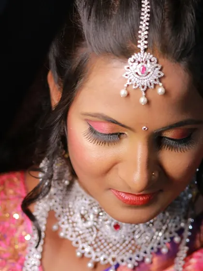 An elegant high-angle shot of a bride, showcasing her makeup and maang tikka.