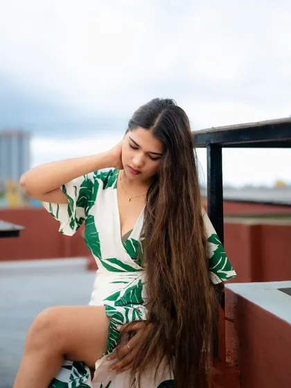 A portrait of a model on a rooftop, with a beautiful sky in the background. Her pose and the open space create a sense of freedom and style.