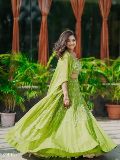 A full-length shot of a woman in a green lehenga, twirling happily. We capture the fun and movement of the celebration.