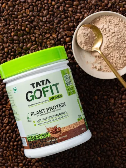 A product shot styled with raw ingredients. Here, we used coffee beans to visually represent the "Cafe Mocha" flavor of the protein powder.