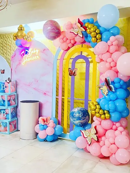 A vibrant butterfly-themed baby shower with a pink and blue color scheme, perfect for a gender reveal or a "He or She" party.