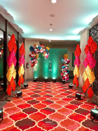 The end of the walkway, leading to a photo backdrop with the couple's monogram and a lush floral arch.