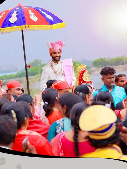 Capturing the grand entrance of the groom, surrounded by family and friends, during a traditional wedding procession (Baraat).