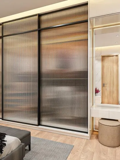 This view of the daughter's bedroom showcases the fluted glass wardrobe doors and the elegant built-in dressing table with a large mirror and ample bookshelf space.
