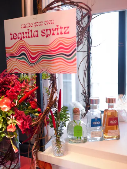 A "make your own tequila spritz" station, beautifully decorated with floral arrangements and themed signage. This interactive element adds a fun and personal touch to the party.