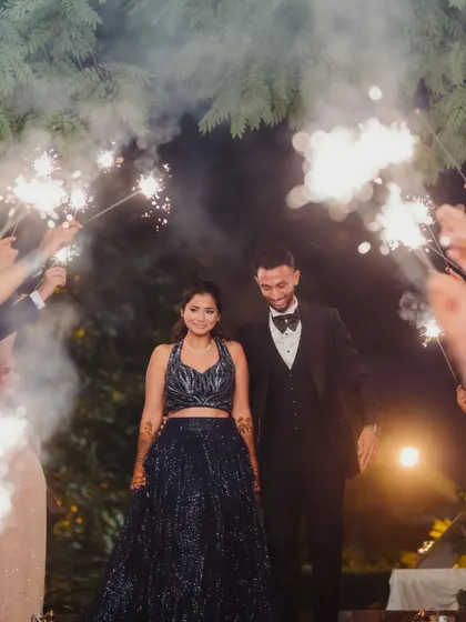 The couple makes a grand entrance to their Sangeet through an archway of sparklers held by their friends and family, a truly cinematic and unforgettable moment.