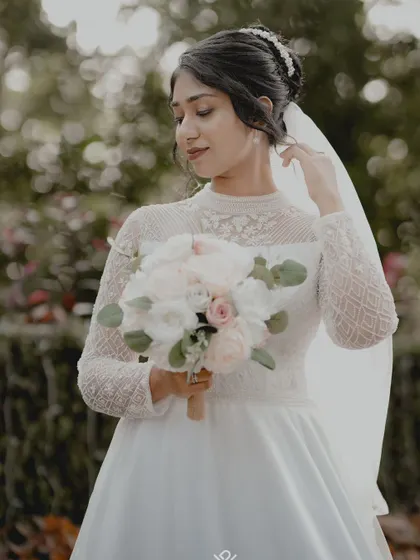 A three-quarter portrait of a Christian bride, capturing the elegant details of her lace-sleeved dress.