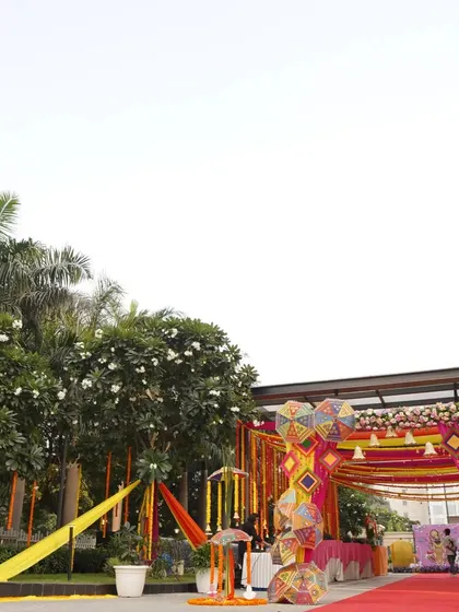 A wide view of a Mehendi entrance, where I used colorful Rajasthani umbrellas and bright fabric drapes to create an immediate sense of fun and festivity. It’s a perfect welcome for a daytime celebration.
