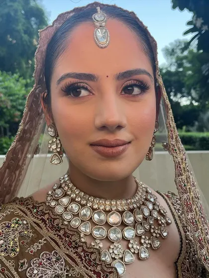 A side profile showing the beautiful contour and highlight. The makeup is expertly applied to catch the light in the most flattering way.
