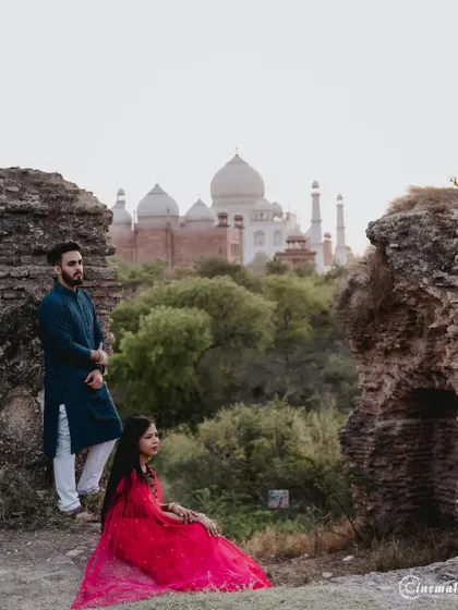 A creative composition using ancient ruins to frame the Taj Mahal in the distance. This shot combines history, romance, and a unique perspective for a truly memorable pre-wedding picture.