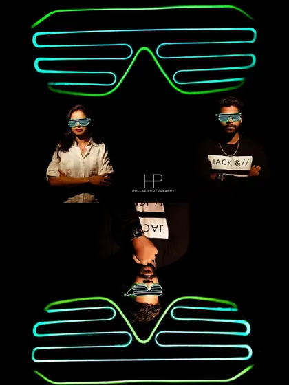 An artistic composition using neon glasses and reflections. This modern and creative approach results in a visually interesting portrait with a vibrant, nightlife feel.