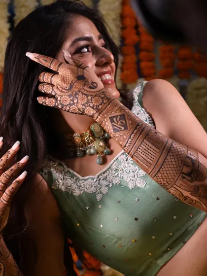 A beautiful bride, her smile and mehandi shining bright. It's a joy to collaborate with talented makeup artists to create the perfect bridal look.